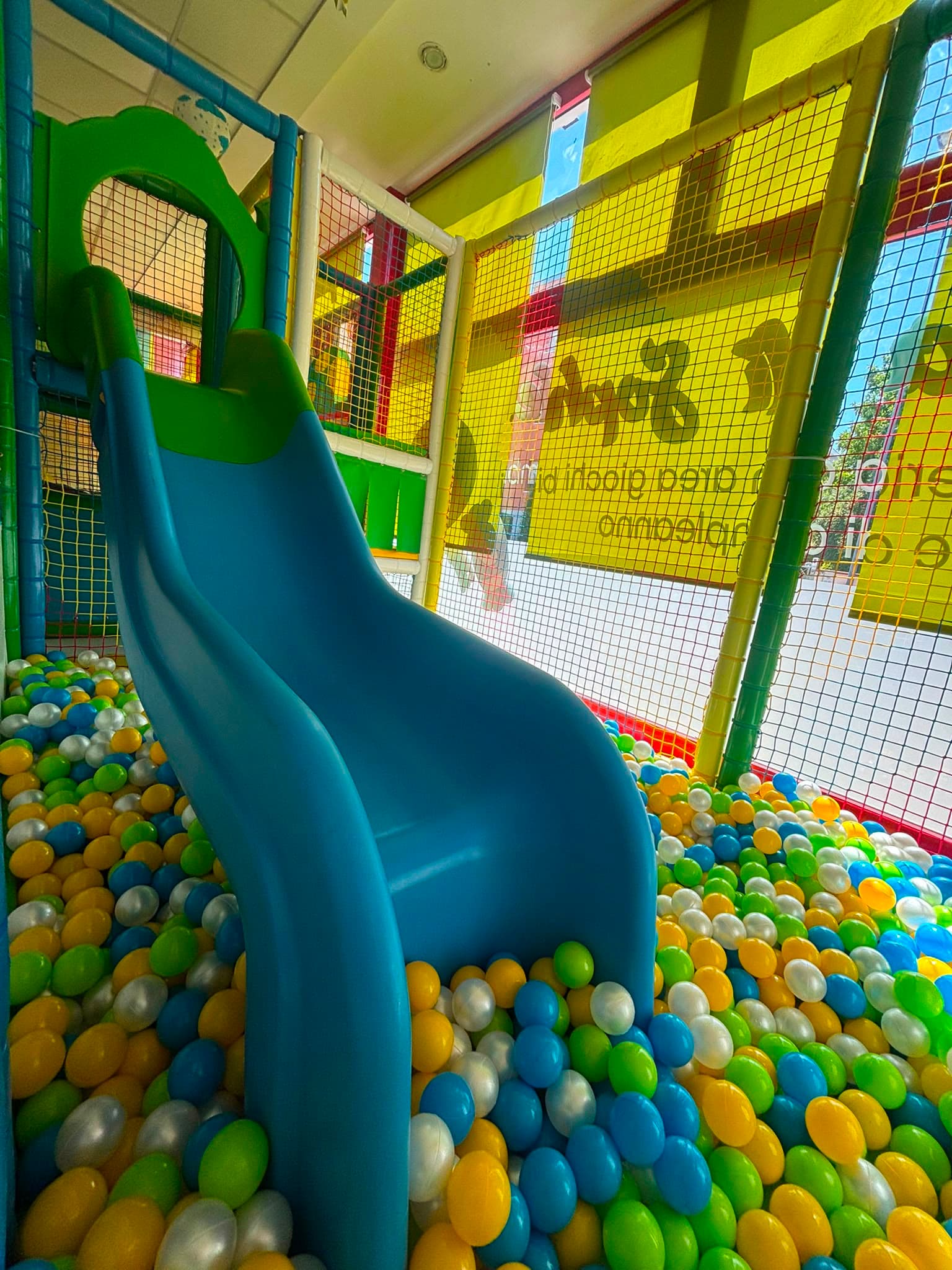 Scivolo blu che scende nella piscina di palline colorate