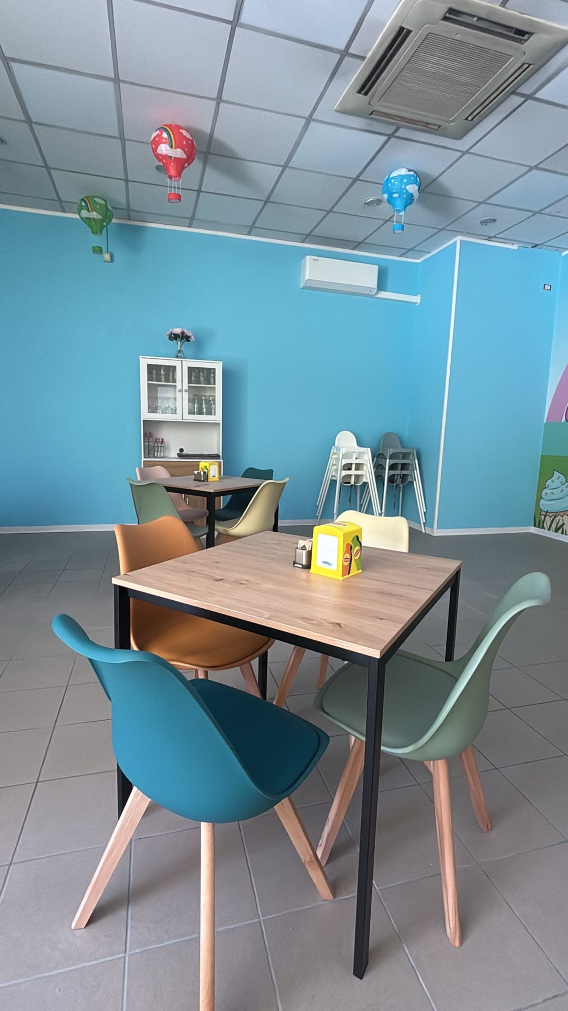 Sala tavoli con sedie colorate per le famiglie